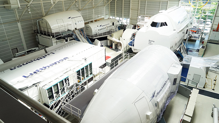 Several Cabin Emergency Evacuation Trainer (CEET) from Lufthansa Aviation Training are located in a hangar.