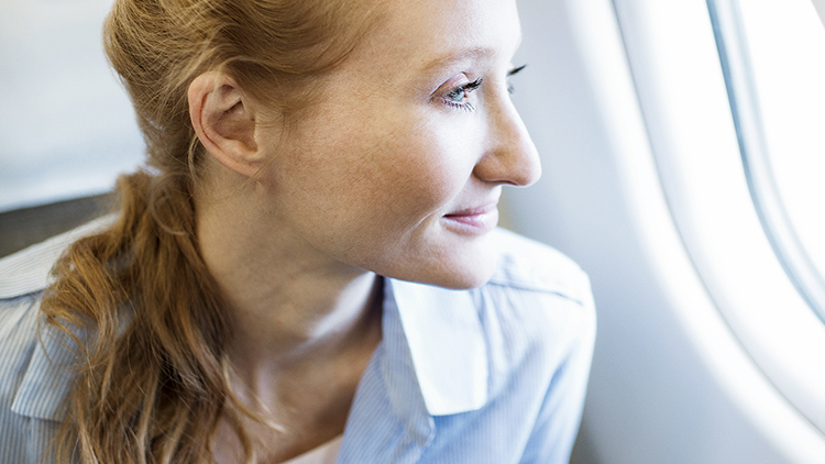 A passenger looks out the window of an airplane