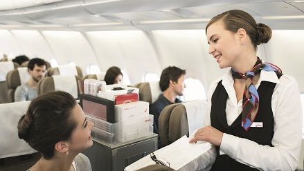A flight attendant is showing a passenger the onboard offerings.