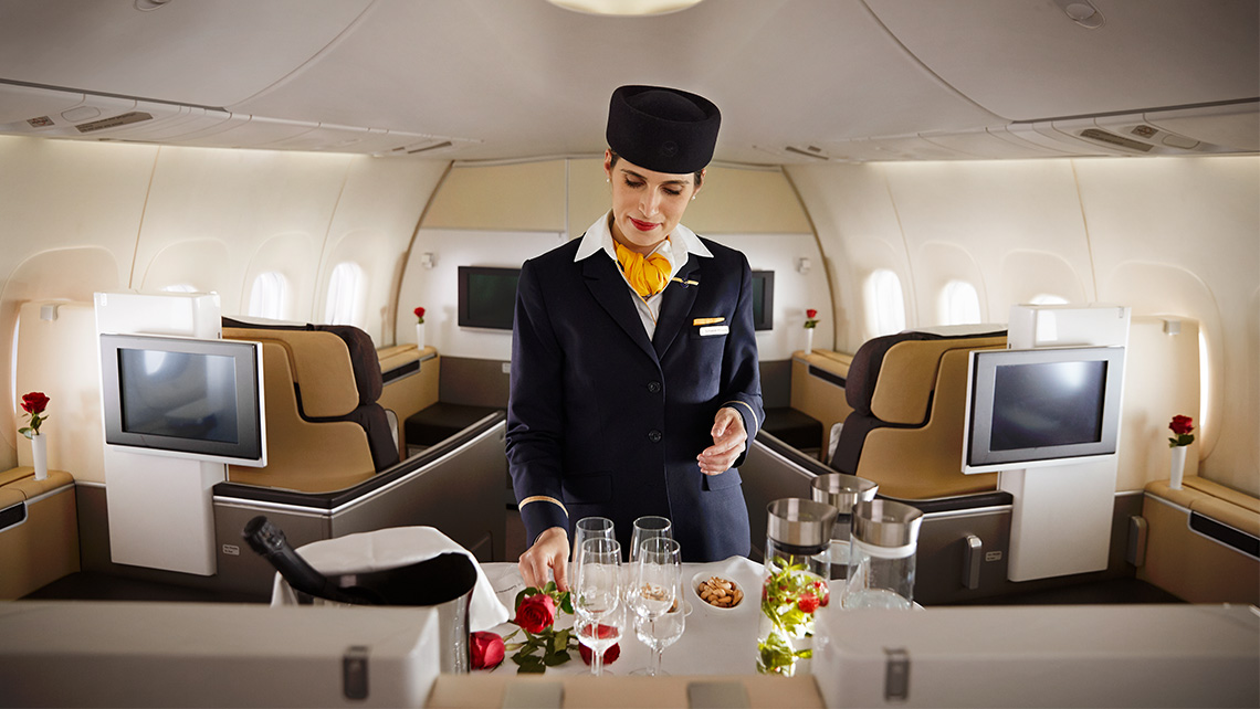 A cabin attendant prepares snacks and drinks for first class on an aircraft