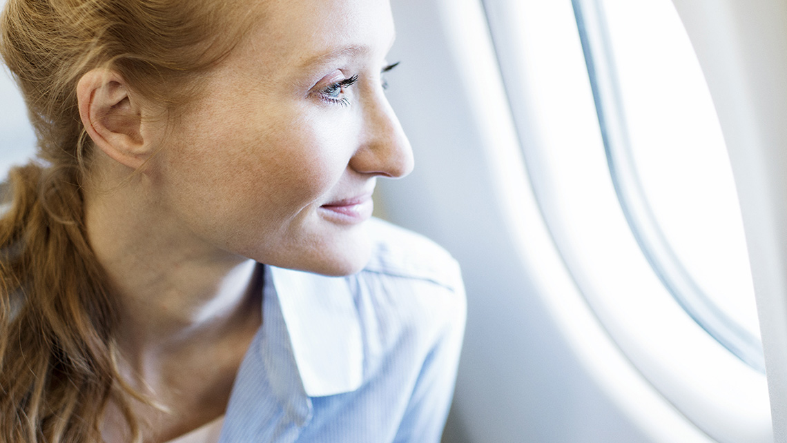 A passenger looks out the window of an airplane