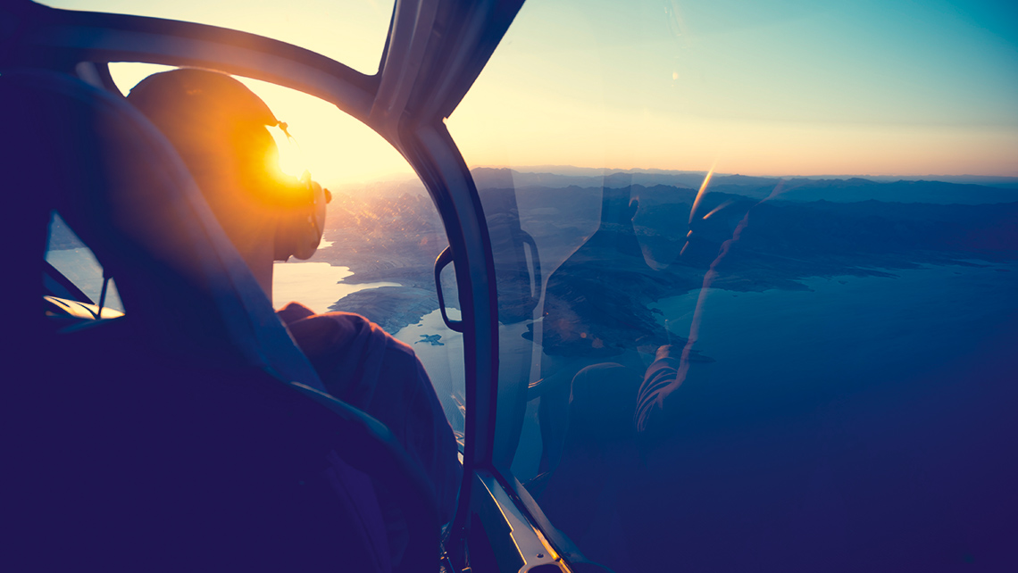View from a helicopter cockpit on a lake landscape at sunrise