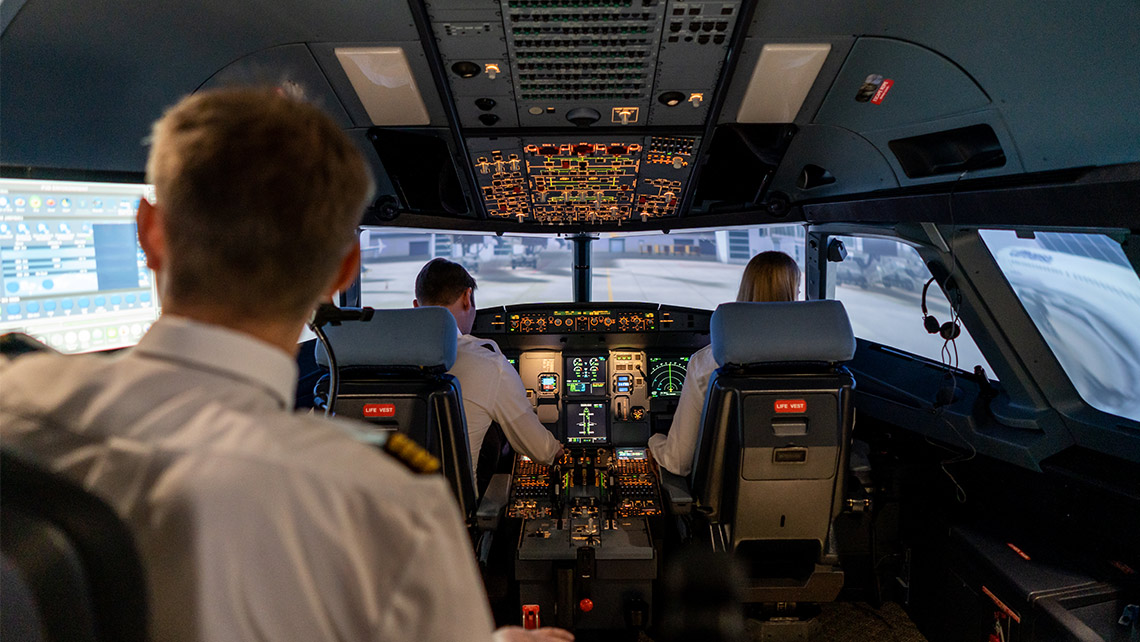 Three Persons sitting in a simulator