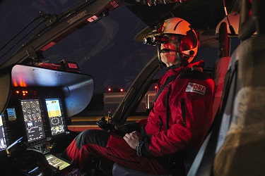 A person in the helicopter simulator in night flight mode.